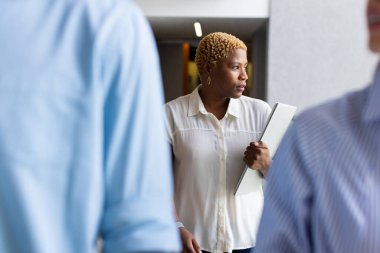 Walking through office corridor, woman holding laptop and looking focused. Business, professional, corporate, technology, concentration, work clipart