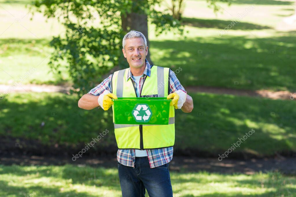 Happy father holding recycling case on a sunny day