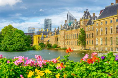 Binnenhof kalesinin manzarası - Het TorentjeLittle Tower ile Hollanda Parlamentosu, arka planda modern binalar ve çiçekler büyüyen Hofvijver Gölü, Lahey, Hollanda