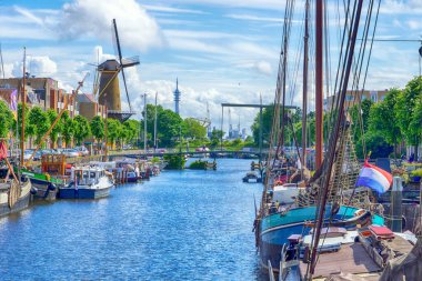 Hollanda 'nın eski tarihi Delfshaven, Rotterdam, Hollanda kanalı yakınlarındaki geleneksel yel değirmeni ve demirli tekneler