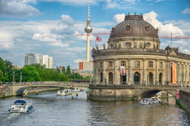 Müze Müzesi 'ndeki Bode Müzesi İmparatoru Friedrich Müzesi ve TV kulesi ve arka planda güneşli bir günde Berlin, Almanya' da turizm tekneleri bulunan Spree Nehri.