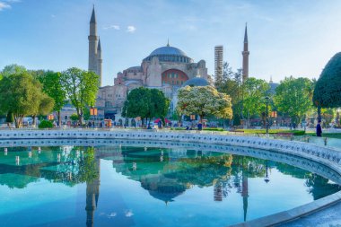 Ayasofya 'nın güzel manzarası, ilkbaharda İstanbul, Türkiye' de gün doğumunda çeşmenin suyuna yansıdı