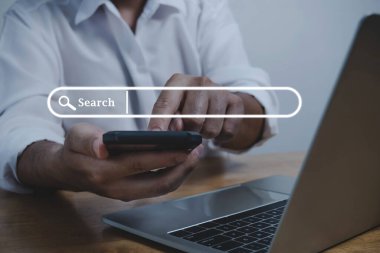 Sanal ekran arama tuşuna sahip cep telefonu ve dizüstü bilgisayar kullanan insanlar, arama bilgileri, iş finansmanı, internet veri teknolojisi ve veri arama motoru kavramını araştırıyor
