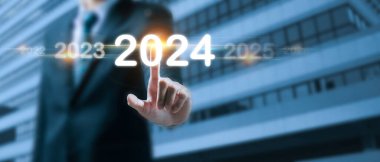 2024 yılının iş adamı, 2024 yılını hedef alan sanal ekranla, 2023 'ten 2024' e, strateji, yatırım, iş planlaması, mutlu yıllar konsepti.