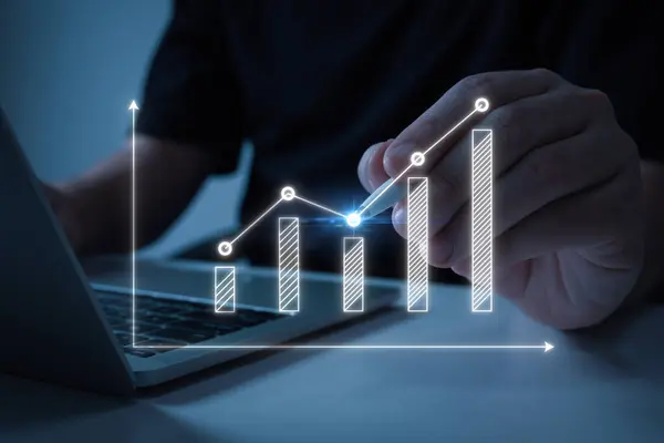 ラップトップコンピュータとバーチャルグラフィックグラフ図 株式市場 投資取引 デジタル技術 取引統計 ビジネス戦略コンセプトを使用しているビジネスマン ストックフォト