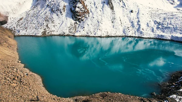 蓝水的高山湖像镜子一样反射着冰川 你可以看到高山的最高峰 湖水已部分结冰 有些地方有大石头和大雪 莫兰湖 — 图库照片