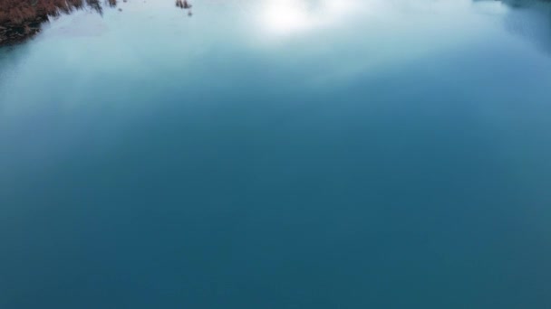 湖の木々とターコイズブルーの鏡水 水中からの光の流れが見える 秋の山や針葉樹は水の中に反映されます カザフスタンのイシク山湖 — ストック動画