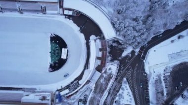 Dağlarda kış Alp Paten Pisti Medeo. Karlı ormanın ve dağların drone görüntüsü. Beyaz bulutlar ve sis vadide. Kar temizleme işlemi başladı. Büyük bir stadyum. Almaty, Kazakistan