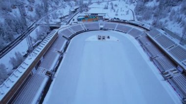 Dağlarda kış Alp Paten Pisti Medeo. Karlı ormanın ve dağların drone görüntüsü. Beyaz bulutlar ve sis vadide. Kar temizleme işlemi başladı. Büyük bir stadyum. Almaty, Kazakistan