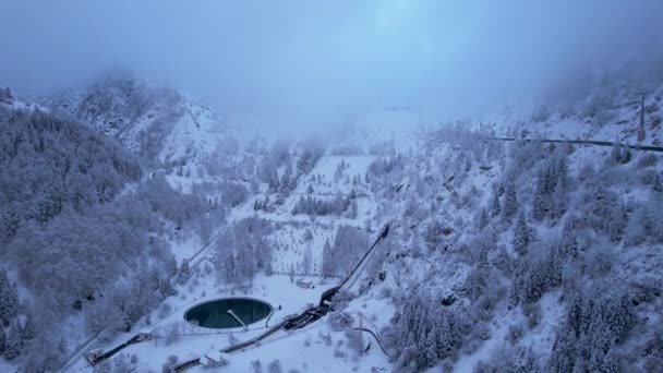 阿拉木图雪山 有针叶树 山水的蓄水池 Medeo水坝和健康阶梯一切都被乌云和雪覆盖着 可以看到人和缆车 — 图库视频影像