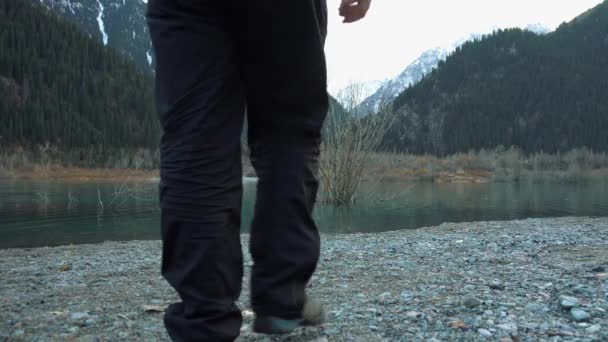 Ένας Τύπος Φόρμα Περπατάει Στην Όχθη Μιας Λίμνης Του Βουνού — Αρχείο Βίντεο