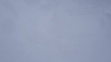 Dağlarda kış Alp Paten Pisti Medeo. Karlı ormanın ve dağların drone görüntüsü. Beyaz bulutlar ve sis vadide. Kar temizleme işlemi başladı. Büyük bir stadyum. Almaty, Kazakistan