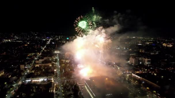 市内中心部の花火からの巨大な明るい閃光 アルマトイの夜の街のドローンからの空中の景色 色のついたライトとランタン 人々は休んでいる 車が来る 市内の休日 — ストック動画