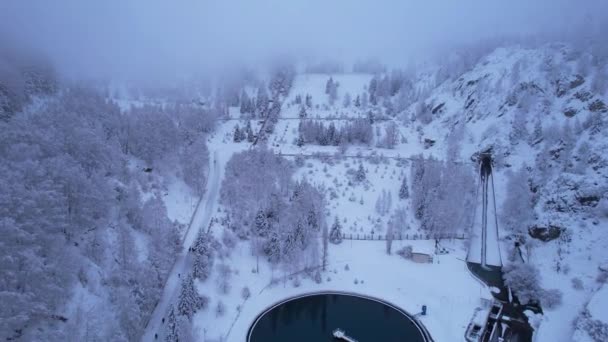 アルマトイに針葉樹の雪の山 山の水の貯水池 メディアダムと健康のはしご 雲と雪に覆われている 人々とケーブルカーが見えます — ストック動画