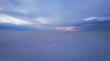 Göksel bir bulut okyanusu. İnsansız hava aracıyla uçmak. Gün batımında güneşin açık sarı ışınları bulutların yüzeyine yansımaktadır. Çift katmanlı bulutlar ve yoğun sis. İyi akşamlar. Kazakistan
