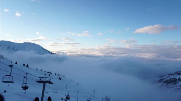 冬季群山中的云雾构成的史诗般的大海 黄昏时分 在白云中 贡多拉路上的时间流逝了 人们在玩滑雪板和滑雪 Shymbulak Almaty Kazakhstan — 图库视频影像