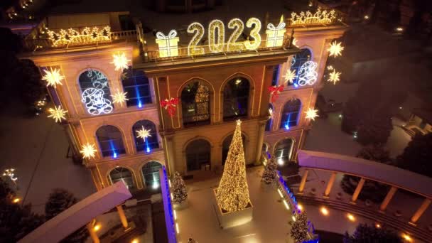 クリスマスと新年のために美しく装飾された家 雪が降っている クリスマスツリーのガーランドが輝いている カルーセル 様々な装飾 ボールやおもちゃ 人々は歩いている 最上階だ アルマトイ — ストック動画