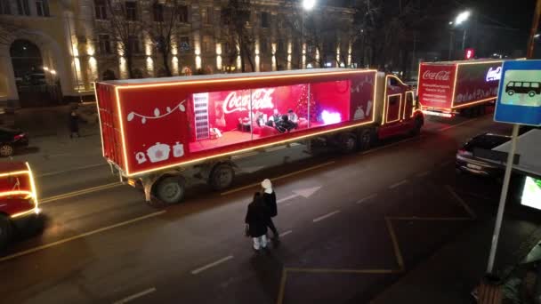 红色的可口可乐大卡车正穿过这个城市 在车里 受欢迎的人挥挥手 人民是幸福的 黄色的灯在燃烧 假期快到了 Almaty 2022 — 图库视频影像