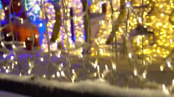 明るい装飾ハッピーニューイヤー2023とメリークリスマス フェンスの上のガーランド ネオン照明の数が輝いている 明るい大きなクリスマスツリー 装飾された家や路地 お祭り気分 アルマトイ — ストック動画