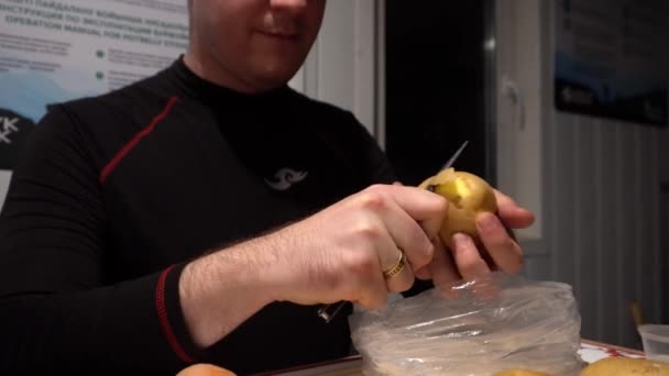 Хлопець Ножем Руках Очищає Картоплю Очищає Кладе Сумку Чорні Ноги — стокове відео