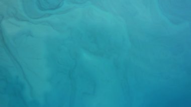 Top view of the turquoise water of a mountain lake. Beautiful divorces as if painted in watercolor. The color ranges from light blue to dark. Clear water. Trees, mountains and birds are reflected