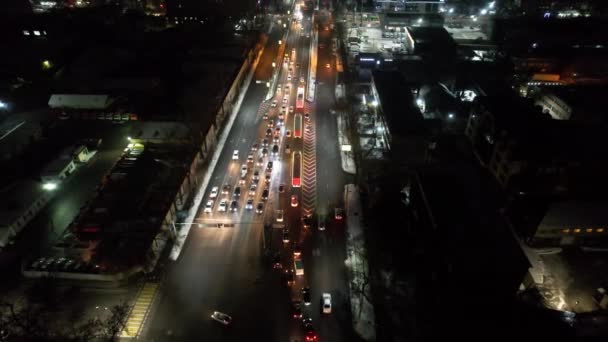 コーラのある赤いトラックが街を通っています 車のキャラバンでドローンからの空中ビュー 黄色いライトの赤い車が道路を走っている 明かりが輝いている 2022年12月28日現在 — ストック動画