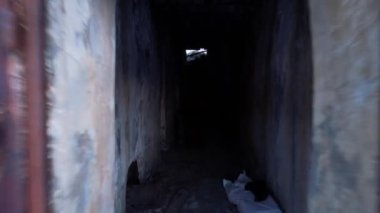 I went into an abandoned stone prison in the mountains. Rusty metal at the entrance, shabby walls. Multiple cameras. Two stoves in the walls with rusty doors. There is a backpack and a bag.