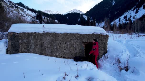 Ένας Τύπος Μπαίνει Μια Πέτρινη Καλύβα Στα Βουνά Υπάρχουν Χιονισμένα — Αρχείο Βίντεο