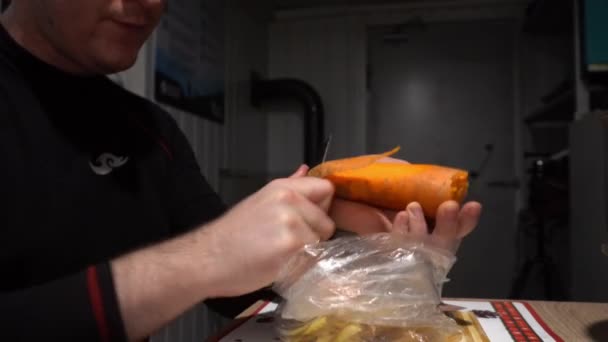 Guy Knife His Hands Peeling Carrots Peels Puts Bag Black — Stock Video