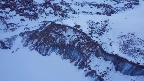 雪下有巨大的冰川 山上有巨大的岩石 蓝色的冰裂开了 冰封的莫兰湖裂缝沿着冰层流淌 冰和岩石的连接 一个危险的地方从上面看 — 图库视频影像
