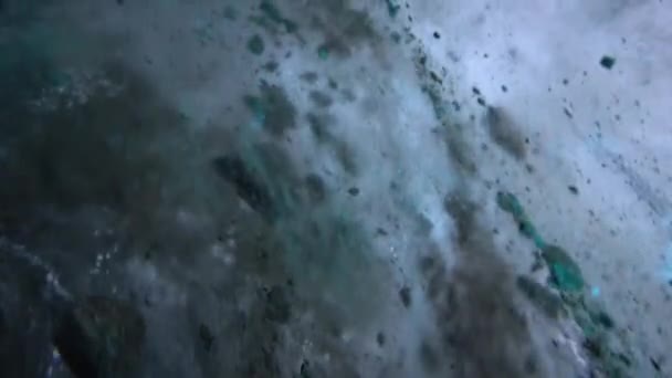 氷の洞窟の中の氷のターコイズ純粋な色 場所に石やつららが見えます 氷の壁に雪の光粒 氷の壁に凍った空気の泡 古代の氷河だ グラデーションの色 — ストック動画