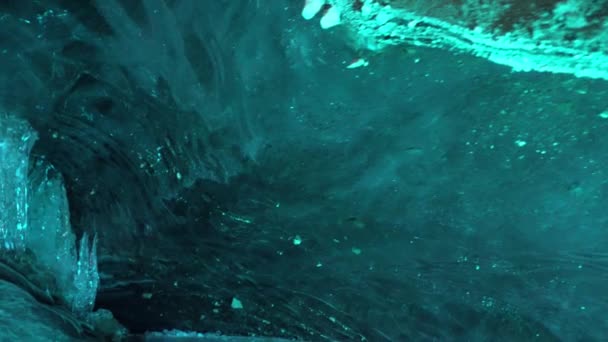 冰洞里绿松石般的冰色 石头和冰柱在一些地方是可见的 冰墙上的小雪花 冰冷的空气在冰墙中起泡 一个古老的冰川 色彩梯度 — 图库视频影像