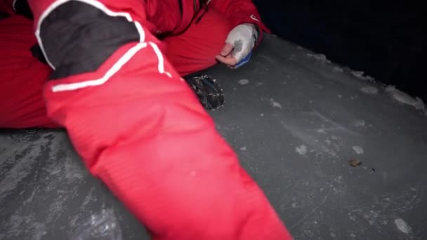 一个家伙在冰洞里用汽油做饭 登山者点燃燃烧器 切香肠和西红柿 把鸡蛋打破 放在煎锅里煎 从食物中提取的蒸汽 冰墙是蓝色的 地面是灰色的 — 图库视频影像