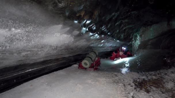 Guy Backpack Moves Ice Cave Beautiful Ice Walls Shimmer Dark — Stock Video