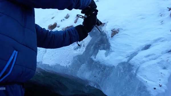 남자는 등산용 나사를 빙판에 끼우고 굴착기가 얼음을 들어가서 얼음을 깨뜨린다 — 스톡 사진