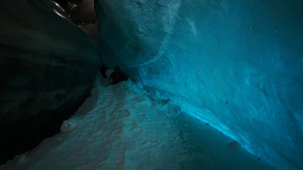 登山者的财物躺在冰洞里 冰的绿松石色给人一种特殊的氛围 冰层上有雪 山中冰川内的一个巨大走廊 阿拉木图 — 图库照片