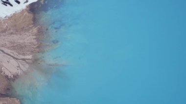 Dağlarda turkuaz mavi suyu olan bir göl. Temiz su, kozalaklı ağaçlar ve karlı dağlar. İnsanlar kıyı boyunca yürür, alçak çalılar büyür. Büyük Almaty Gölü. Kazakistan