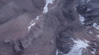 Turuncu kaya duvarlı Charyn Grand Canyon. Dik kanyon duvarlarının, çatlakların ve tünellerin insansız hava aracı görüntüsü. Bazı yerlerde kar var. Güneş ışıl ışıl parlıyor. Büyük Kanyon 'un kardeşi.