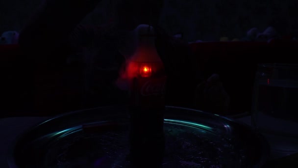 一个火焰喷射器在一瓶可口可乐液体中燃烧着 在透明瓶子中的水下燃烧火花的经验 在水里生火瓶子里冒出大量的烟 — 图库视频影像