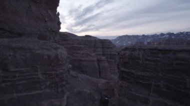 Turuncu kaya duvarlı Charyn Grand Canyon. Dik kanyon duvarlarının, çatlakların ve tünellerin insansız hava aracı görüntüsü. Bazı yerlerde kar var. Güneş ışıl ışıl parlıyor. Büyük Kanyon 'un kardeşi.