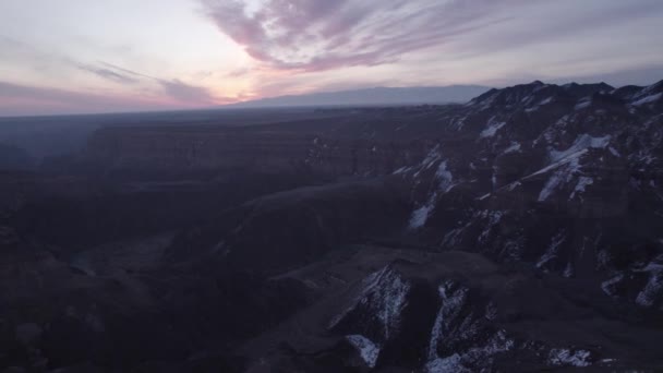 Charyn Grand Canyon有橙色的石墙从陡峭的峡谷墙壁 裂缝和隧道的无人机俯瞰空中 有些地方有雪 太阳在灿烂地照耀着 大峡谷的兄弟 — 图库视频影像