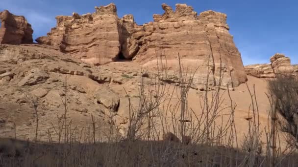 大峡谷Charyn 橙色的悬崖和岩石 有些地方有干枯的灌木丛 也有雪 太阳在灿烂地照耀着 峡谷的断层和裂缝 这地方看起来像火星 — 图库视频影像