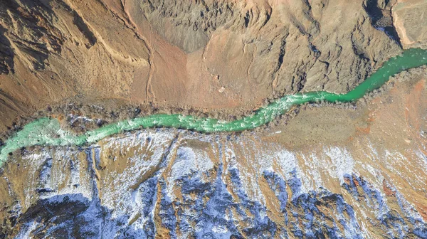 一条长河 在Charyn峡谷里有绿水 有些地方有白雪 灌木和树生长 这条河穿过岩石和悬崖之间的峡谷 山是可见的 无人机视图 — 图库照片