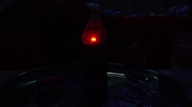 Bir şişe Coca-Cola sıvısında bir maytap yanıyor. Suyun altında şeffaf bir şişede yanan bir maytapla tecrübe edin. Suyun içindeki ateş. Şişeden çok duman çıkıyor..