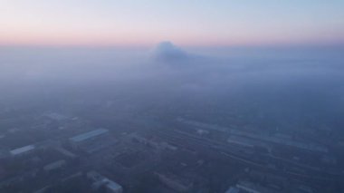 Efsanevi gri sis, gün batımında şehrin üzerinde görülebilir. Evlerin, yolların, arabaların ve parkların insansız hava görüntüsü. Beyaz bulutlar güneşin turuncu ışınlarıyla aydınlatılır. Şehir havasızlıktan boğuluyor. Almaty