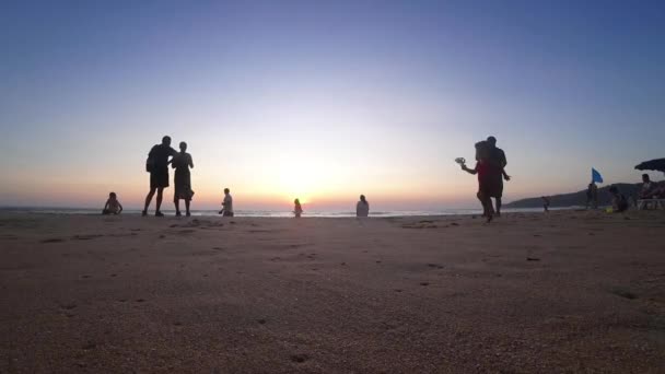 夕阳西下 看海洋 看蓝天 看太阳 人们正在放松 在海滩上散步 孩子们在玩耍 太阳从地平线下升起 是橙色的落日 小云朵卡隆海滩 — 图库视频影像