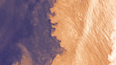 Açık turuncu kum ve koyu su manzarası. Fotoğrafın rengini değiştirmek alışılmadık bir eğimle iyi bir arkaplan olduğu ortaya çıktı. Dalgaların yansıması. Kum ve okyanusun karışımı..