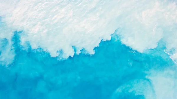 浅蓝色带白沙的水的顶部视图 波浪会升起沙子 并与绿松石水混合在一起 云彩在清澈的海洋上留下的阴影 清澈的大海蓝色的光芒 背景照片 — 图库照片