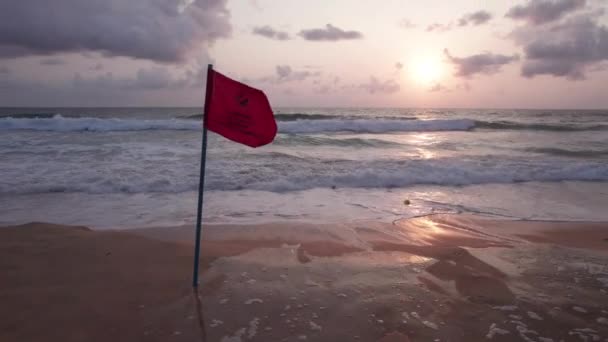 海と雲の景色を望む美しい夕日 海で泳ぐことを禁止する赤い旗があります 黄色の湿った砂 場所にゴミがあります 人々の道 カロンビーチ — ストック動画