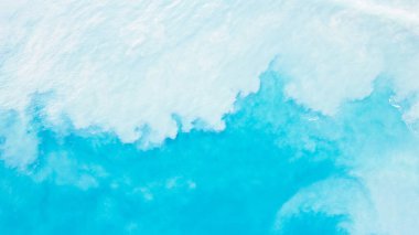 Beyaz kumlu açık mavi su manzarası. Dalgalar kum kaldırır ve turkuaz suyla karışım elde edilir. Açık okyanustaki bulutların gölgeleri. Açık deniz. Mavinin derecesi. Arkaplan fotoğrafı